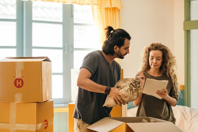 Couple packing boxes for moving the house